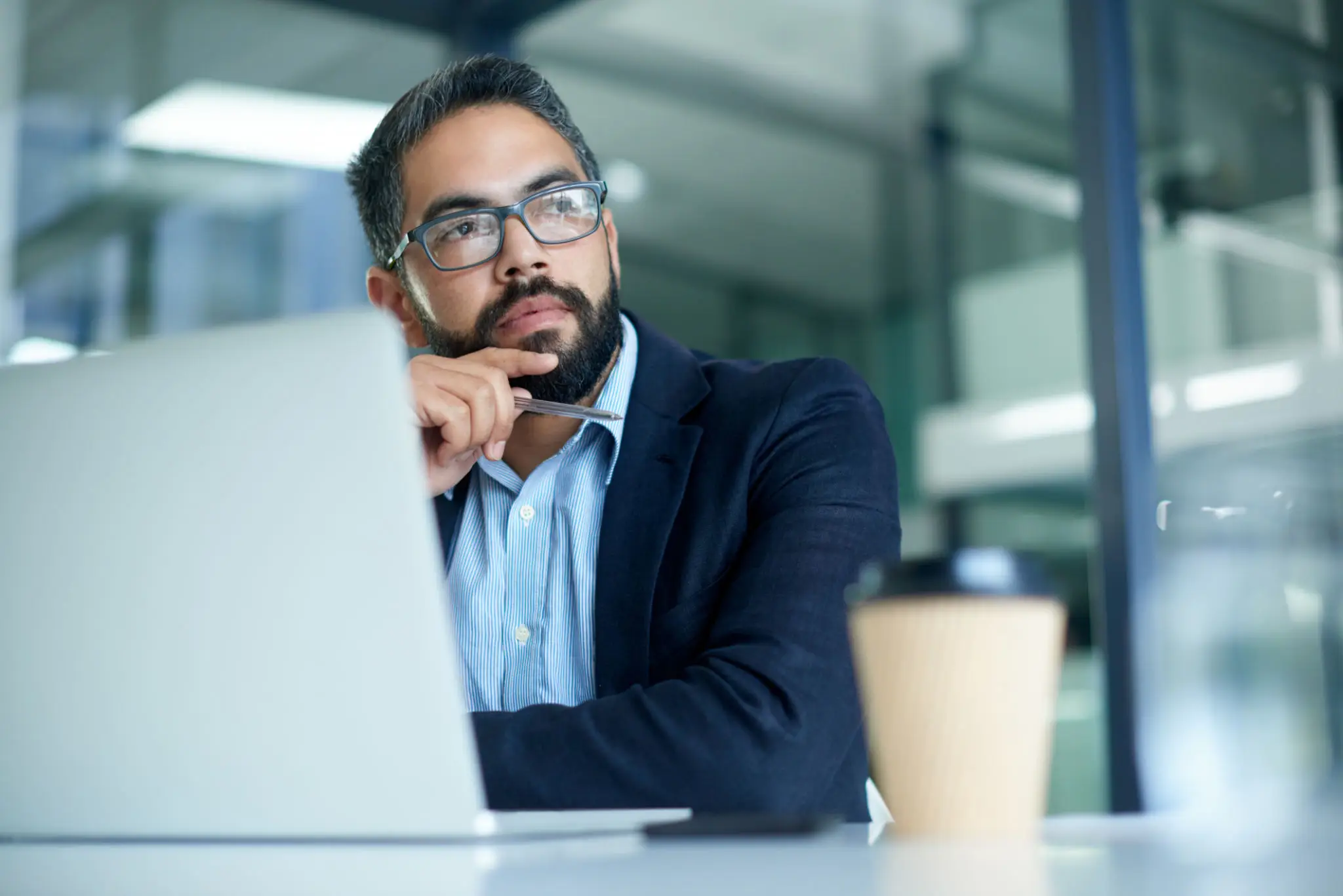 Man thinking while using a laptop.