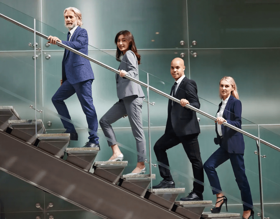 Business professionals walking up glass staircase.