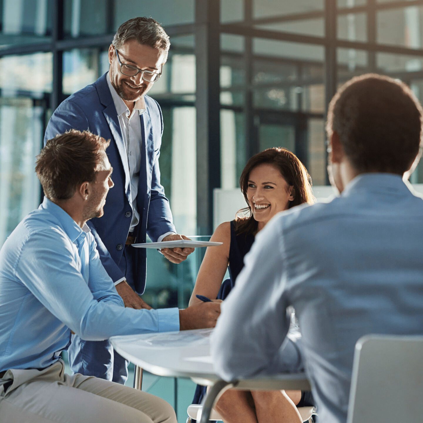 Business meeting with four people smiling.