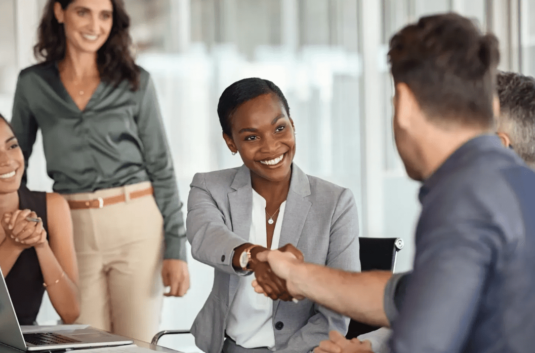 Business meeting handshake and smiling colleagues.