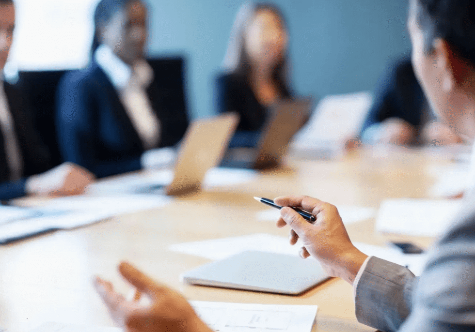 Business meeting with people discussing around table.
