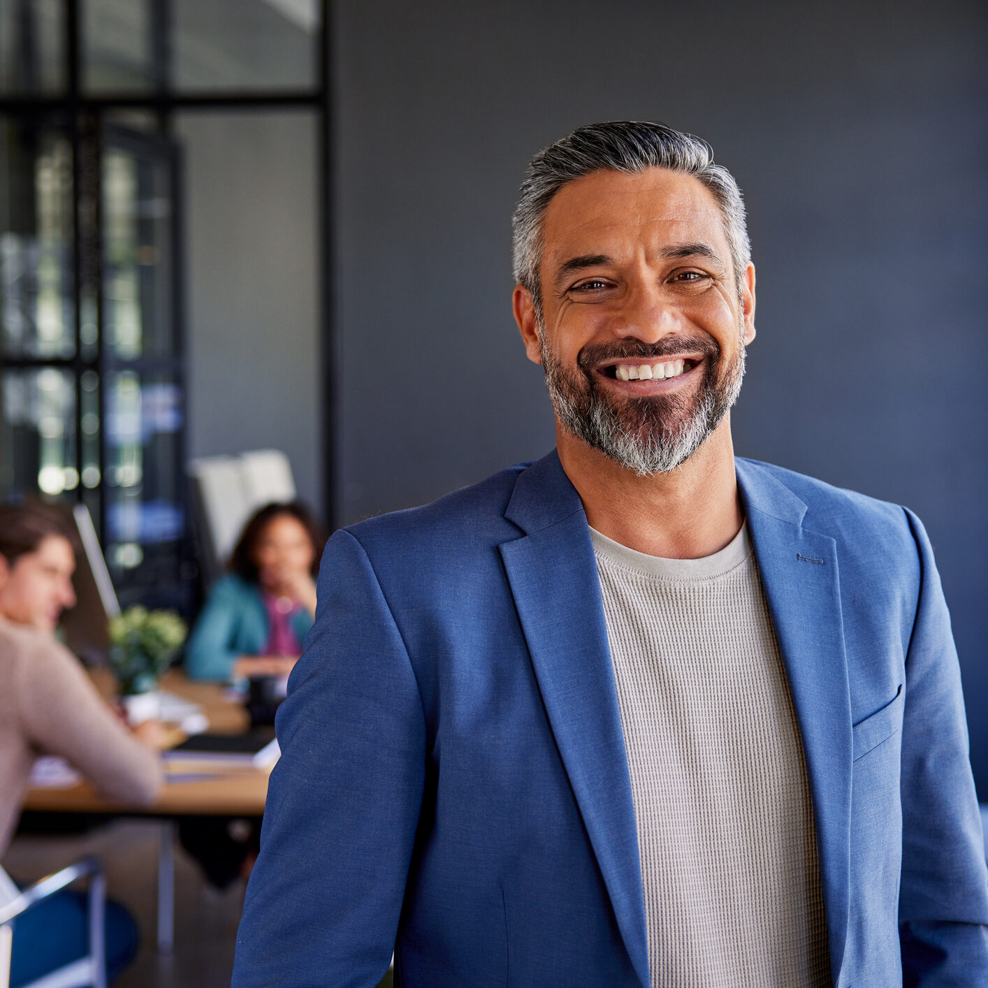 Smiling man in blue blazer at office.