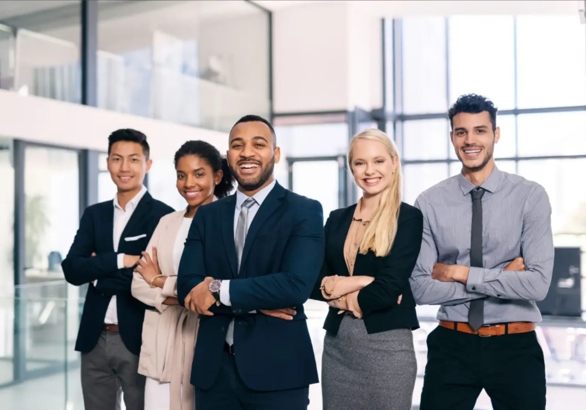 Business team standing with crossed arms, smiling.
